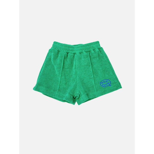 Green | EVERYDAY TERRY SHORTS in green cotton terry, featuring an elastic waist and a blue embroidered logo patch on the lower right leg, shown against a plain white background.
