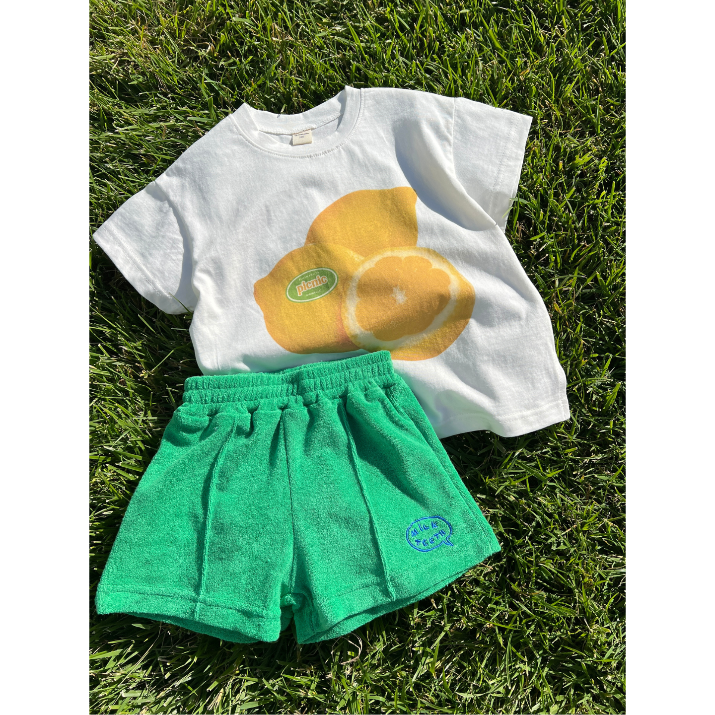 Green | Green shorts matched with the lemon tee laid on the grass