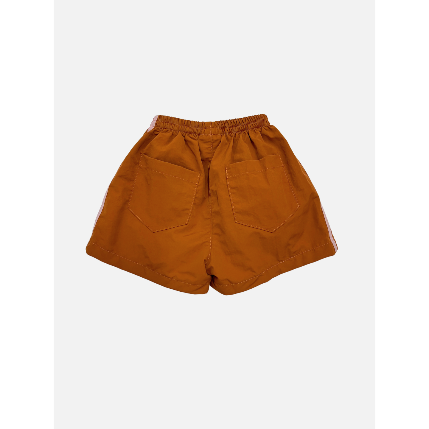 Rust | The SPRINTER SHORTS are orange track shorts with an elastic waist, two back pockets, and white side stripes, made from performance fabric and shown on a plain white background.