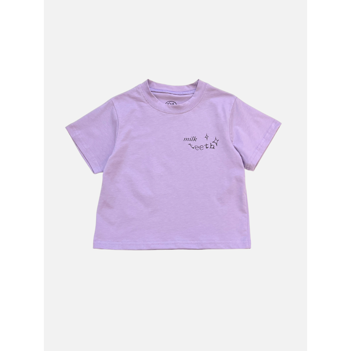 Purple | The MILK TEETH TEE is a purple short-sleeve shirt featuring "milk teeth" and small star designs on the left chest—perfect for fans of unique artist-designed tees.