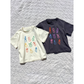 Charcoal | Cream and charcoal color ways of fruit dace tees laid flat on the blanket