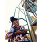 Child playing on a playground structure with a colorful sweater